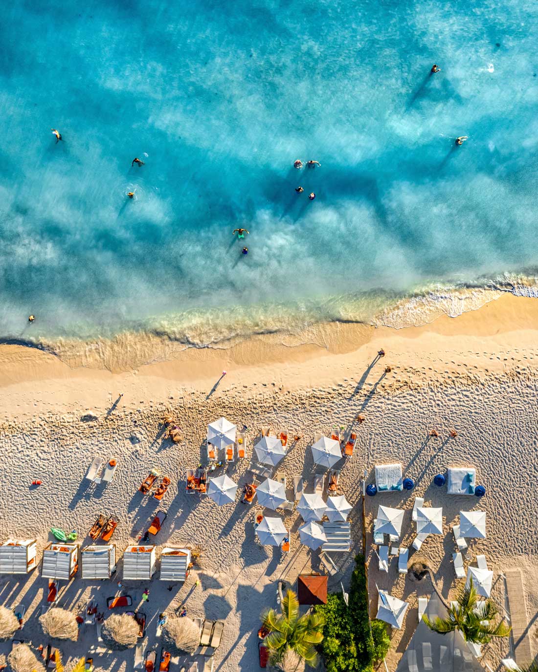 People under umbrellas at beach.